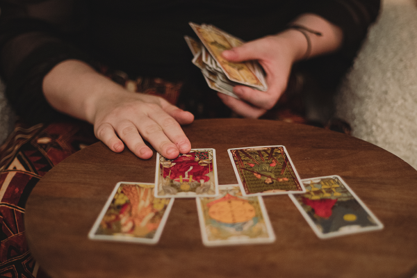 Andlig vägledare lägger tarotkort på ett bord. Andliga tjänster för dig som önskar klarhet.